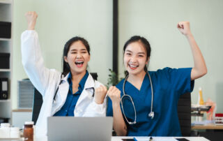 Healthcare students celebrating career success, smiling medical graduates in scrubs and lab coats representing healthcare career readiness in 2026