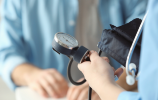 Close-up of a healthcare professional using a sphygmomanometer to measure blood pressure.