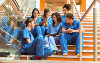 Healthcare students in scrubs collaborating on coursework during hands-on healthcare training at Hawaiʻi Medical College