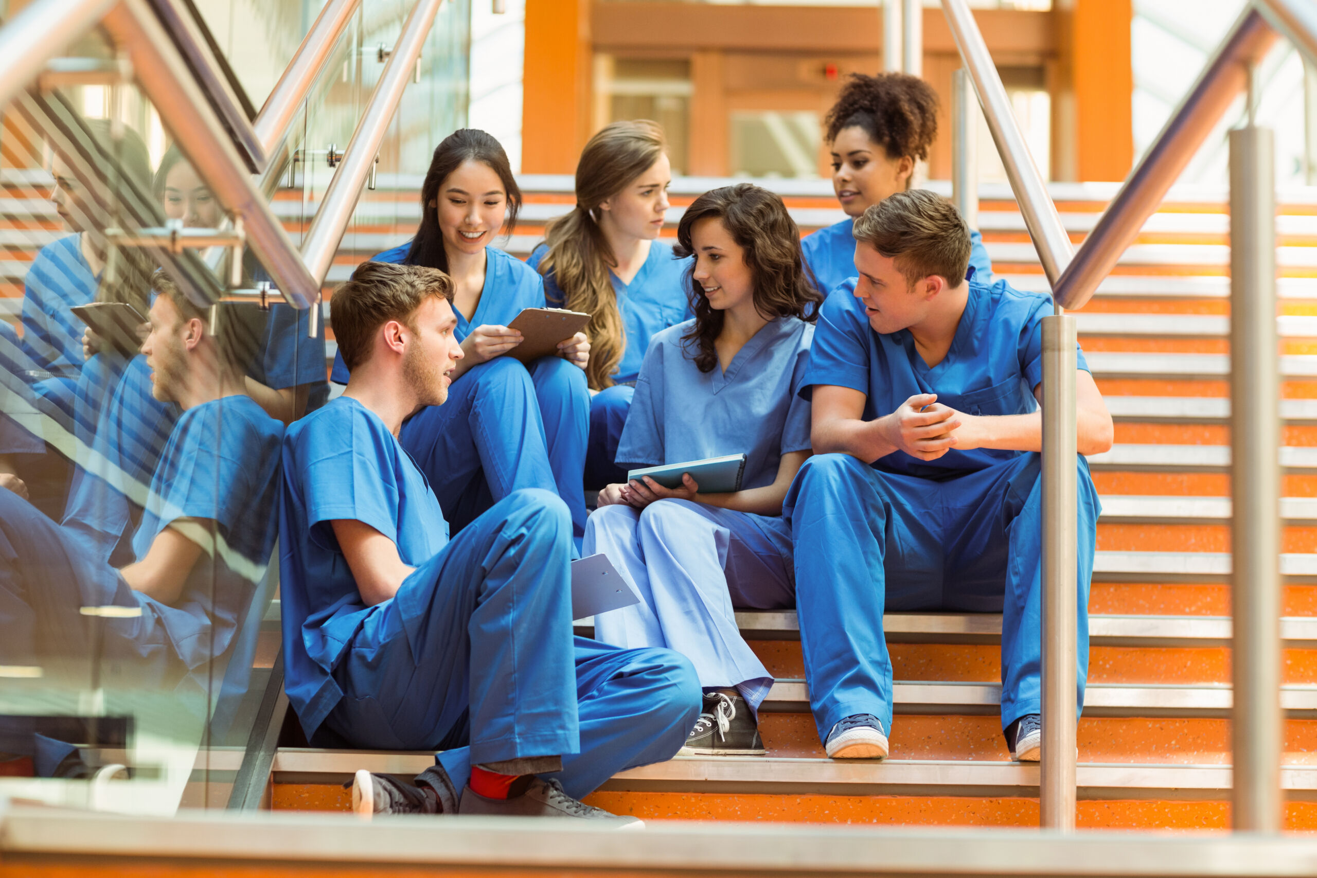 Healthcare students in scrubs collaborating on coursework during hands-on healthcare training at Hawaiʻi Medical College